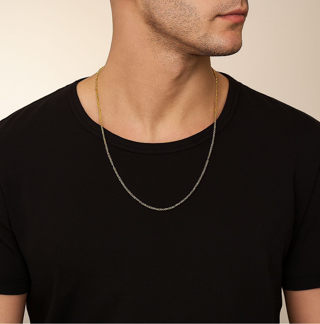 Man wearing a black t-shirt and gold chain necklace against a beige background