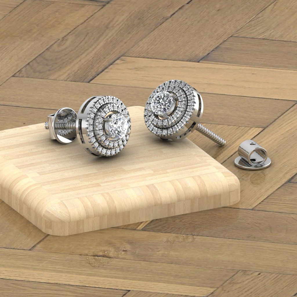 A pair of 18 karat gold natural diamond studs on a wooden surface, with a certificate lying beside them.