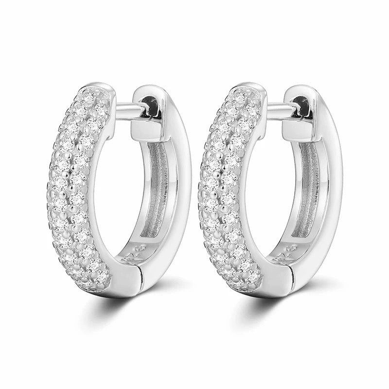 Pair of silver hoop earrings with clear gemstones on a white background