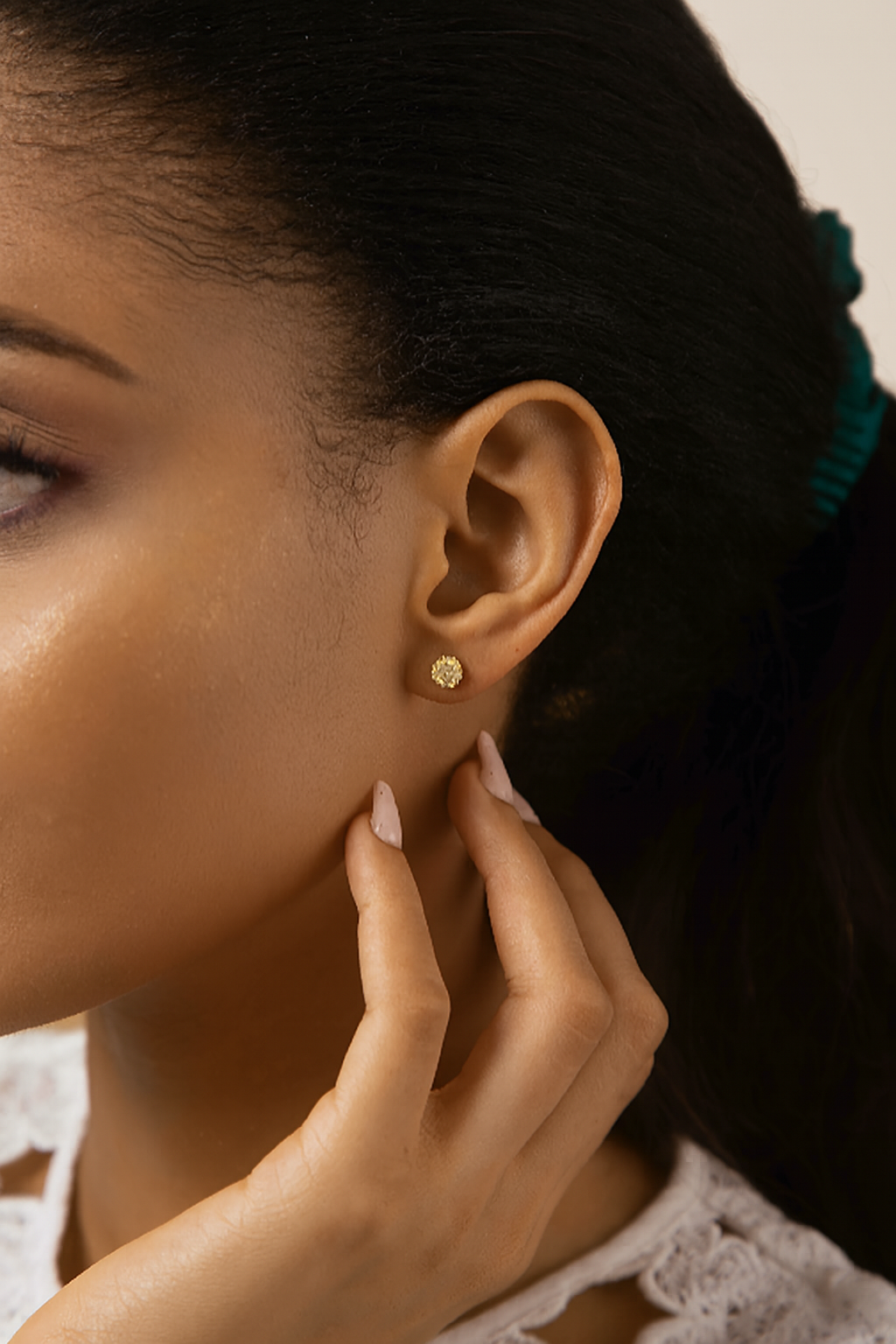 Close-up of a woman wearing a gold earring with a blurred background