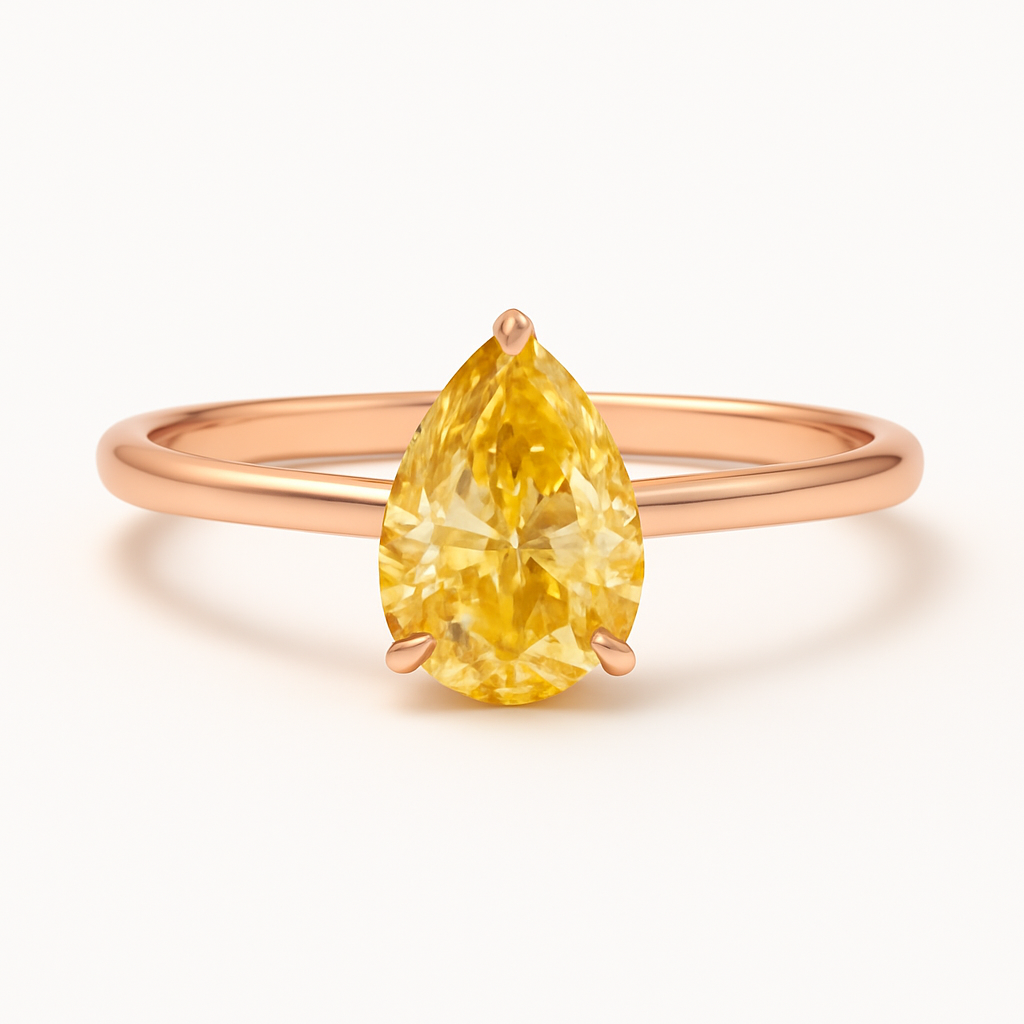 Rose gold ring with a yellow pear-shaped gemstone on a white background