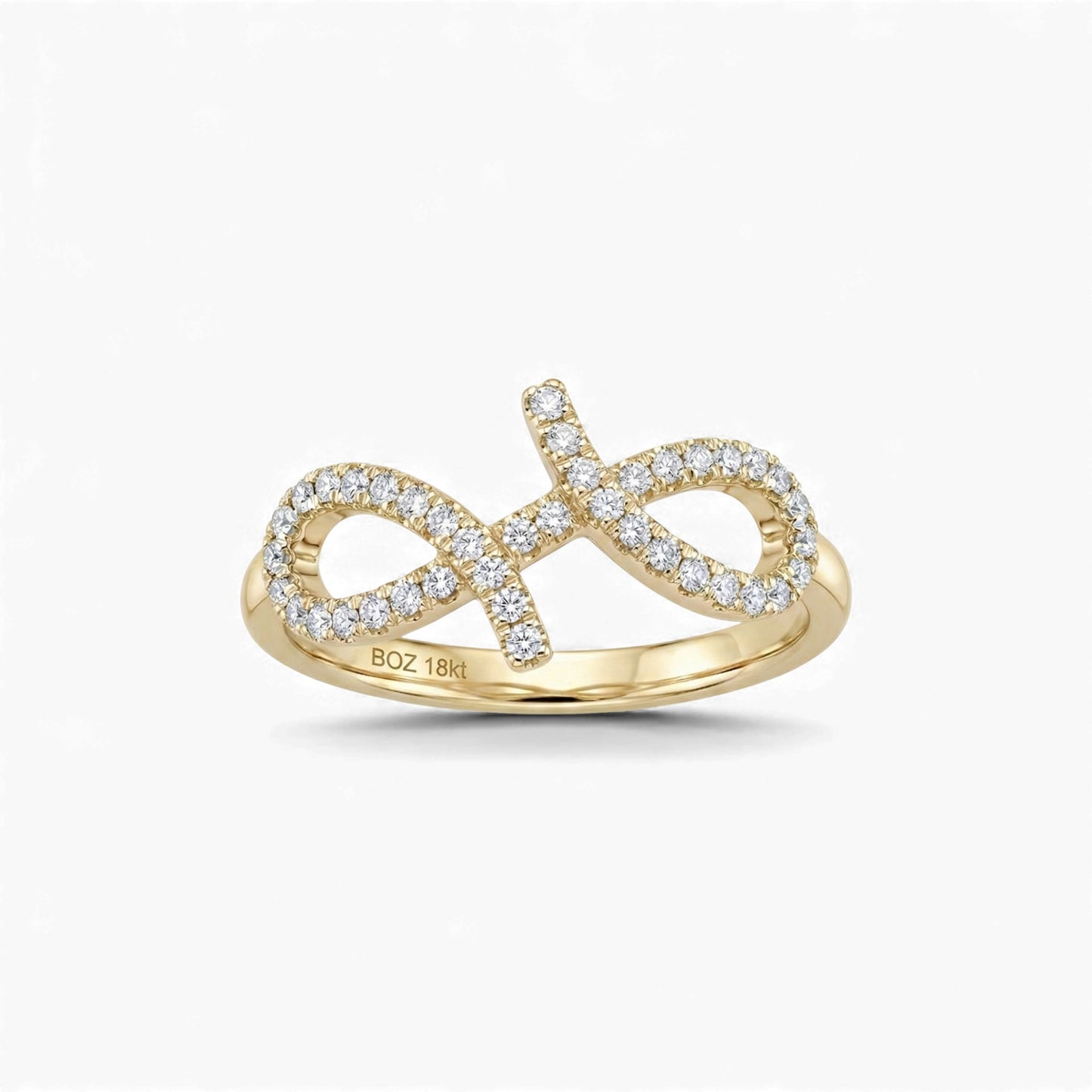 Gold infinity ring with diamonds on a white background