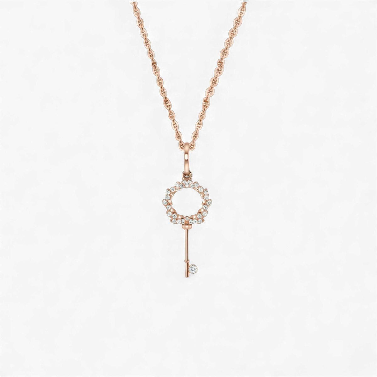 Rose gold key-shaped pendant necklace on a white background