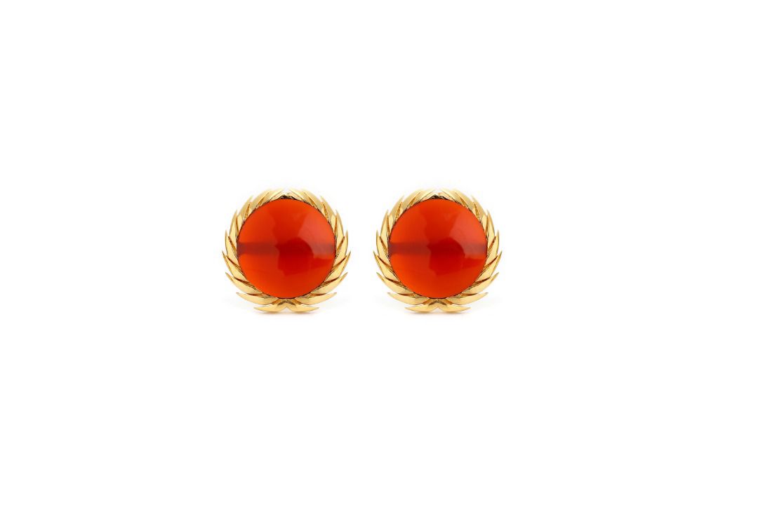 A pair of 18karat gold stud earrings with black onyx centers, surrounded by gold filigree designs.