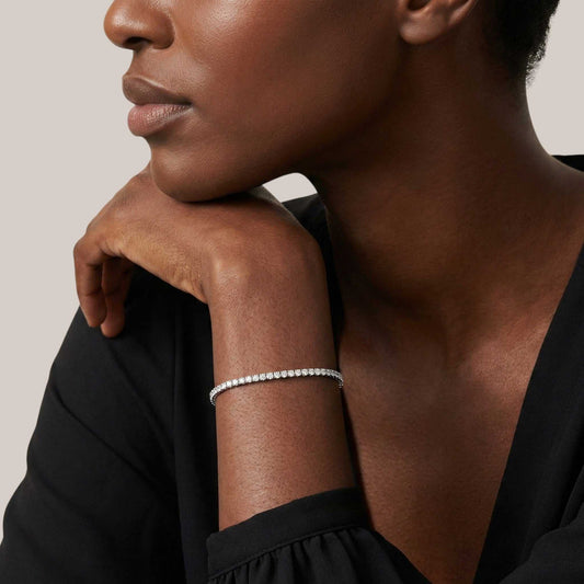 Close-up of a woman wearing a bracelet on a neutral background