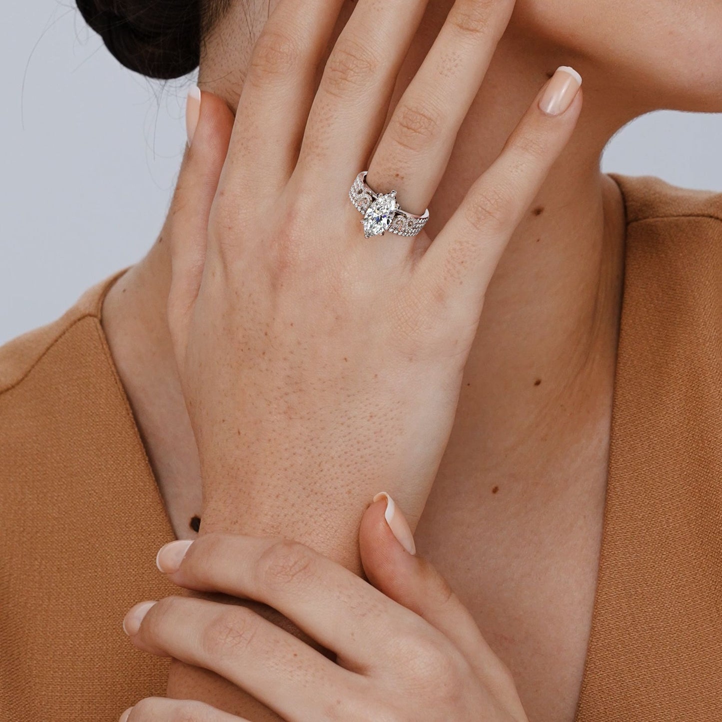 Close-up of a hand wearing an engagement ring with a blurred background