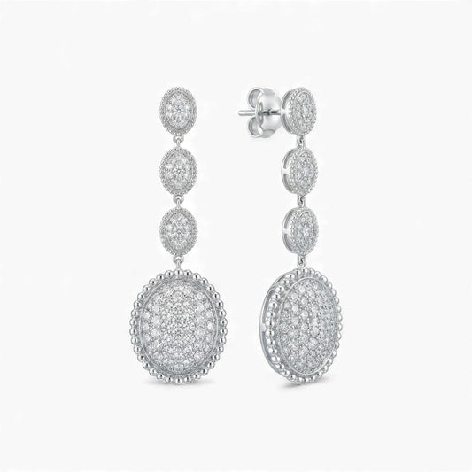 Pair of silver earrings with circular designs on a white background