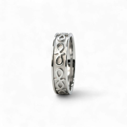Silver ring with intricate design on a white background