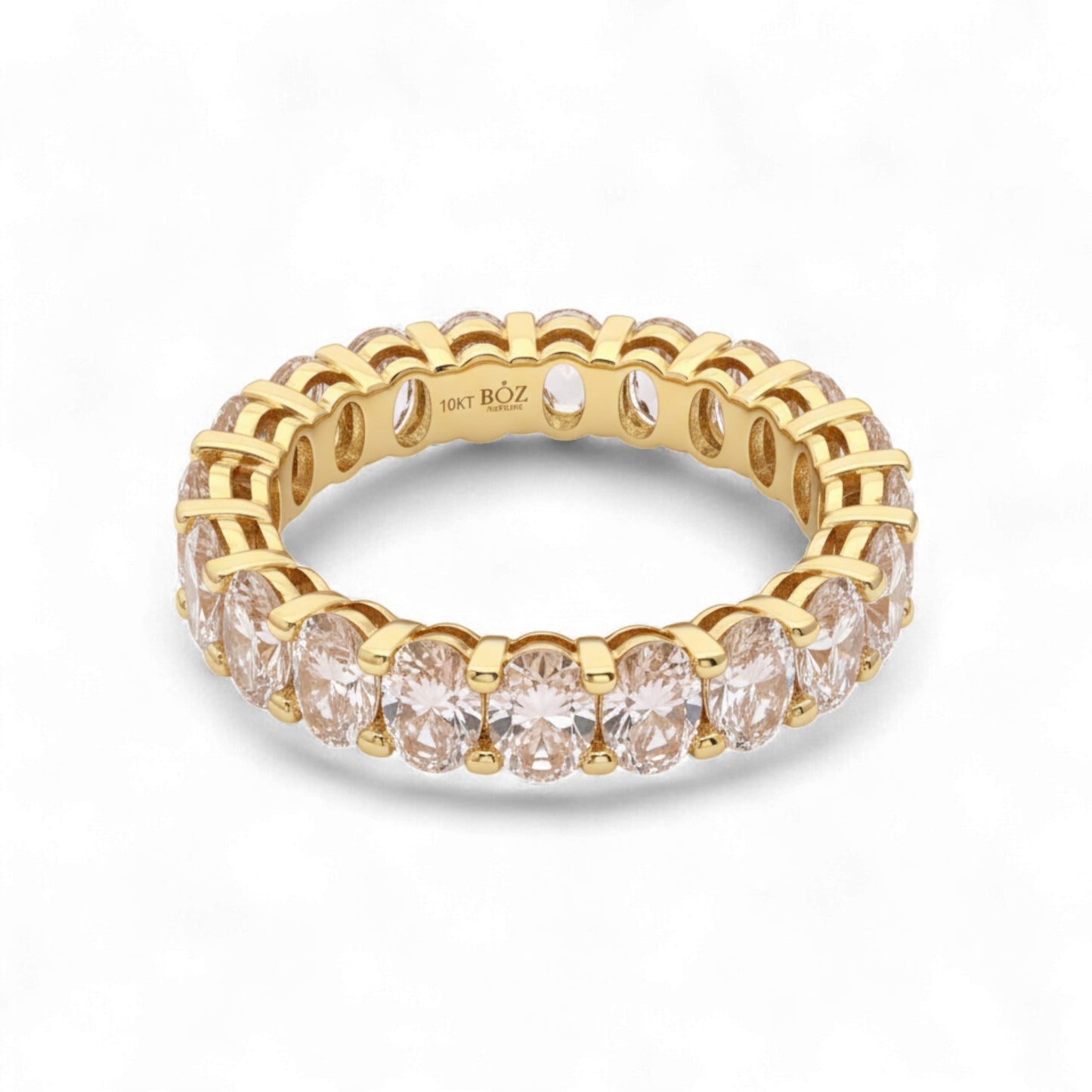 Gold ring with clear gemstones on a white background
