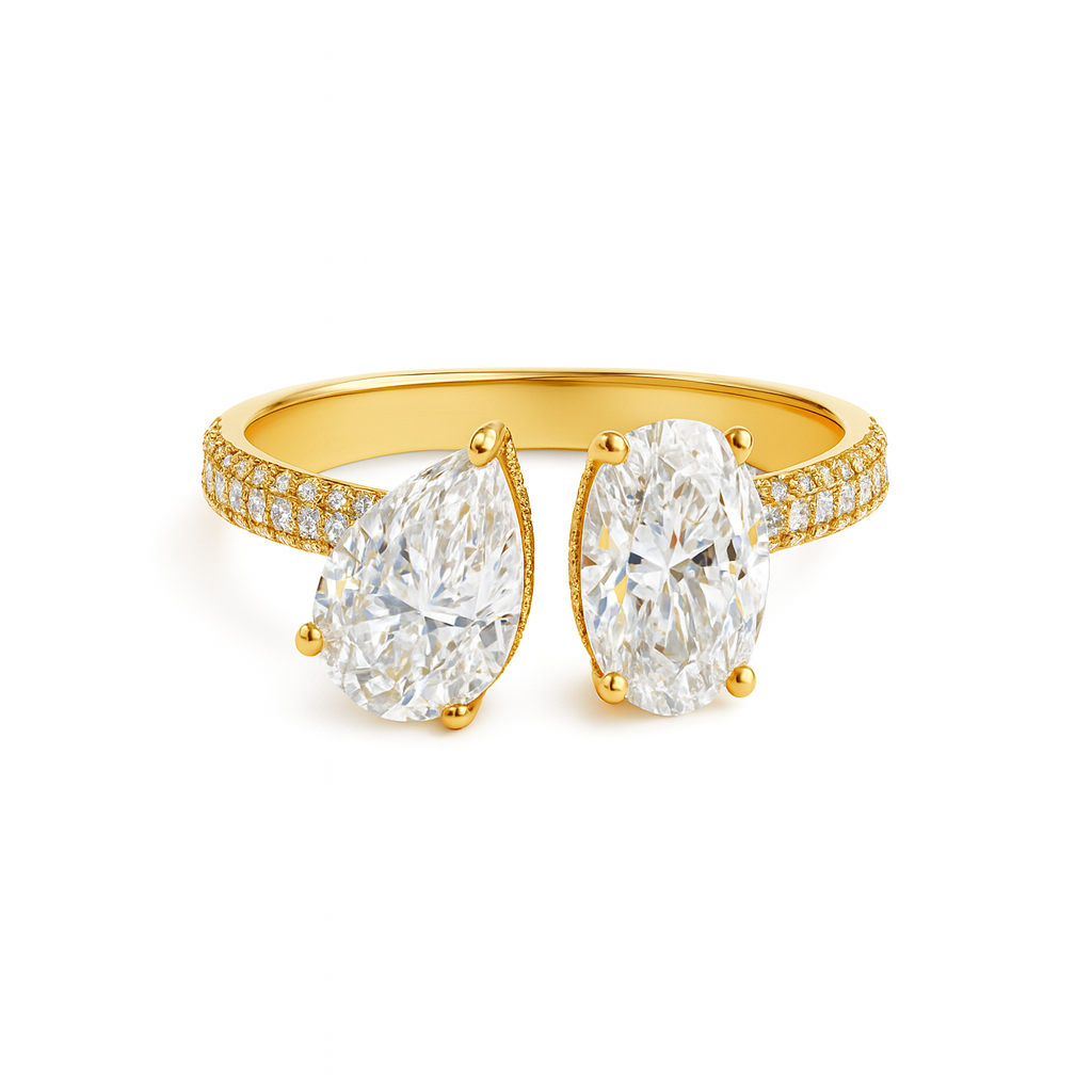 Gold ring with two large pear-shaped diamonds on a white background