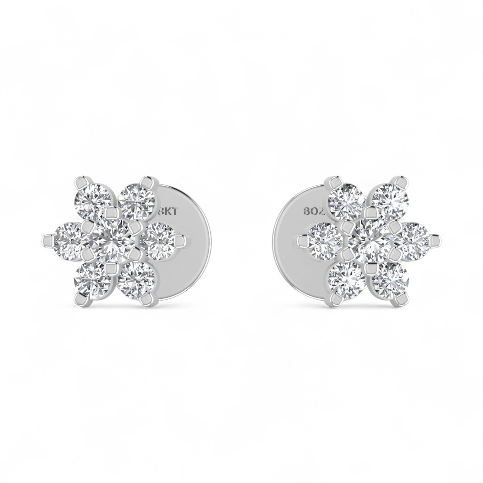 Silver flower-shaped earrings with clear stones on a white background