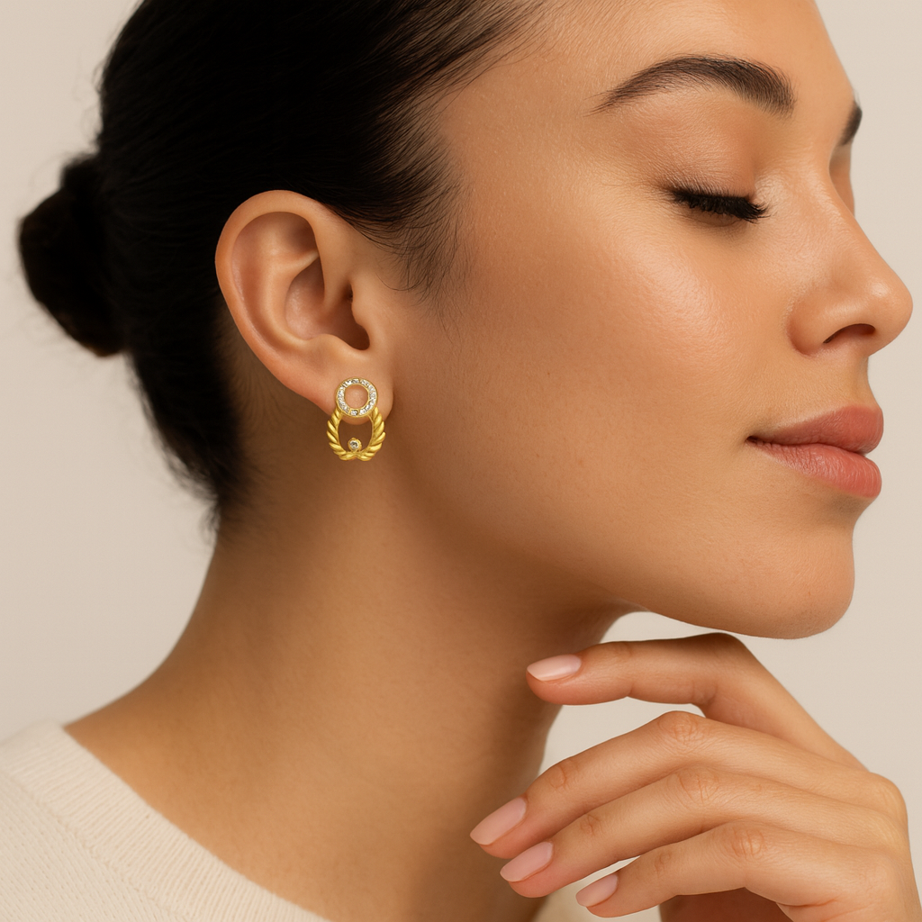 Close-up of a woman wearing gold earrings with a neutral background