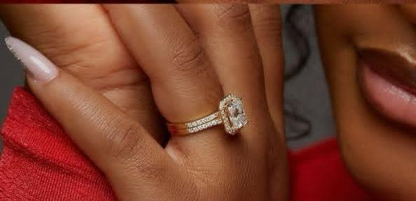Close-up of a hand wearing a diamond ring with a blurred background