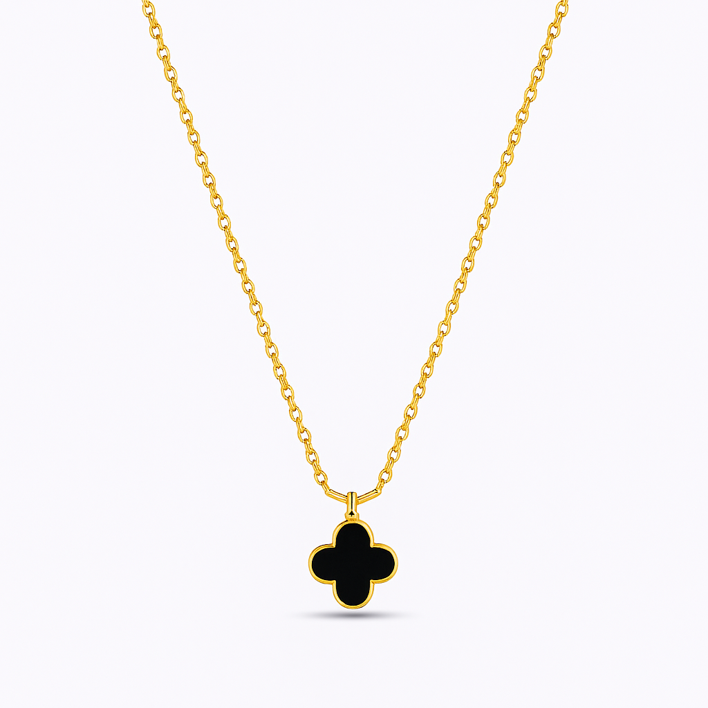 Gold necklace with a black clover pendant on a white background