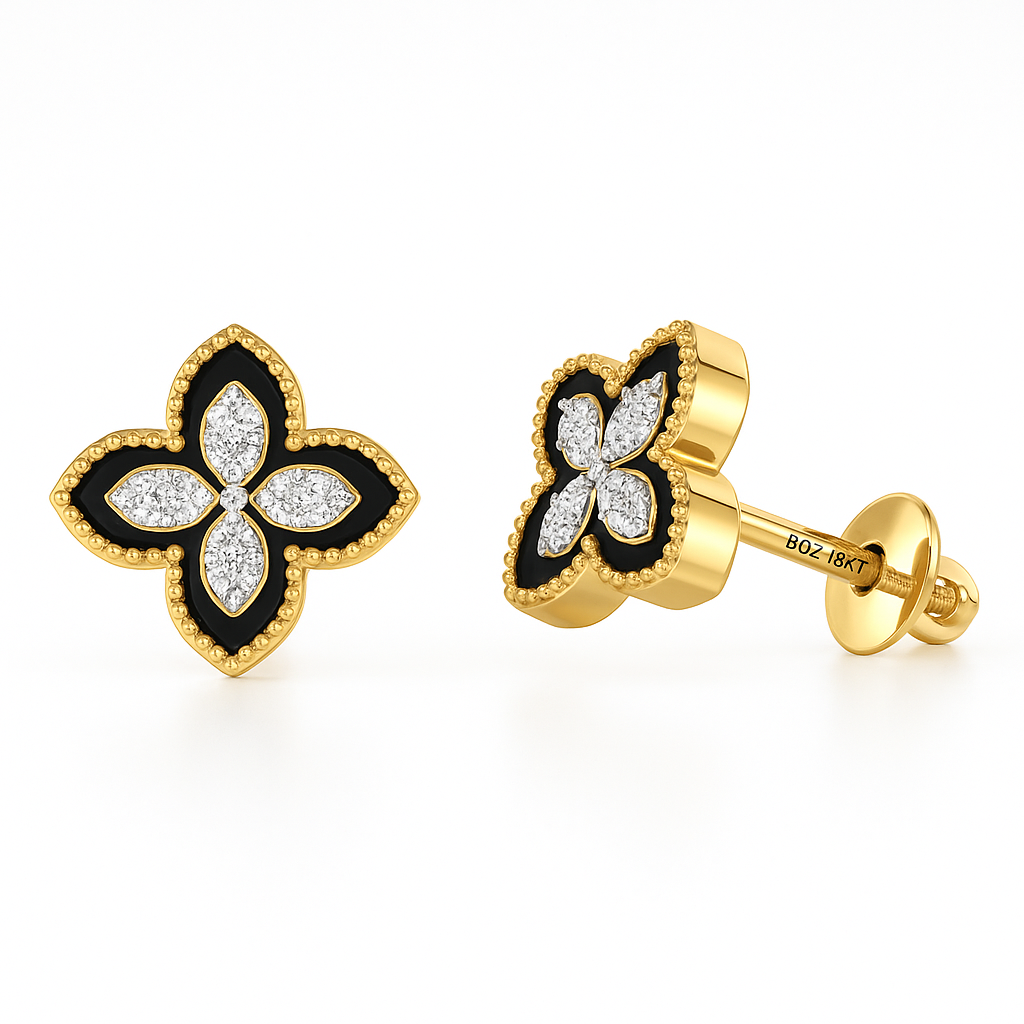Butterfly-shaped gold earrings with black and white details on a white background