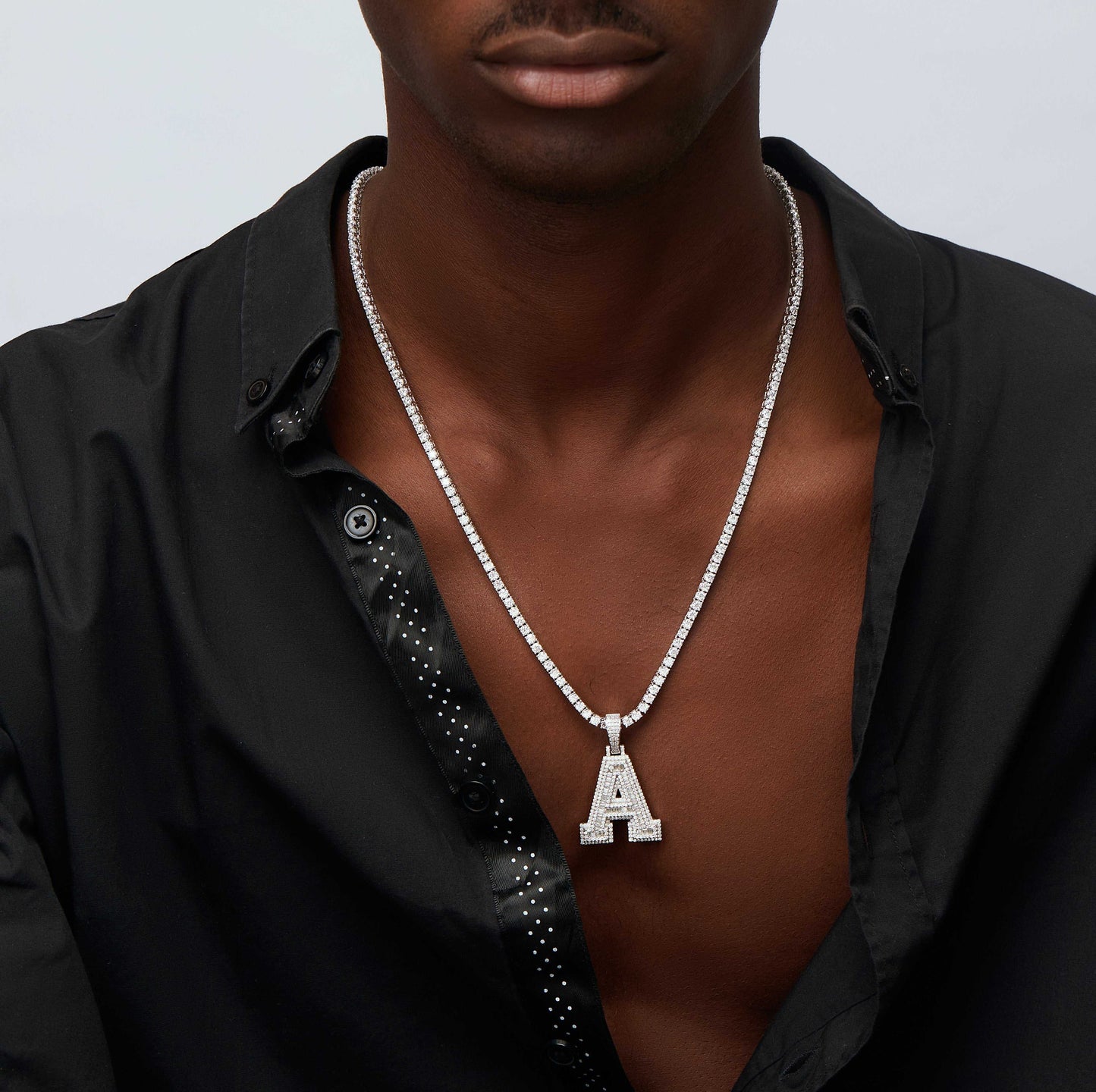 Custom iced out initial pendant necklace with round and baguette cut moissanite in 925 sterling silver worn by man