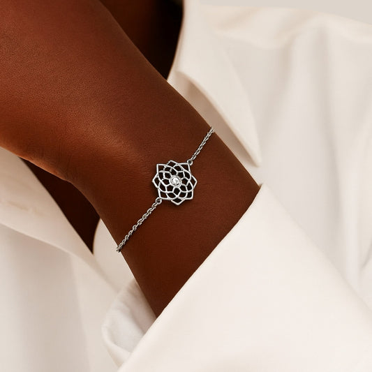 Silver bracelet with a diamond on a wrist against a neutral background