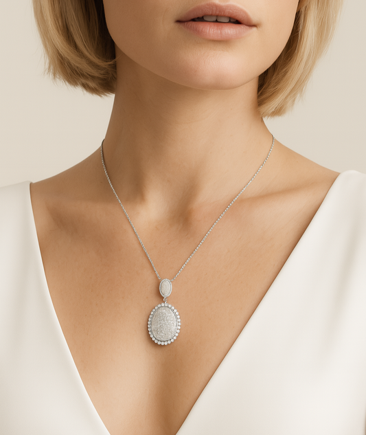 Woman wearing a necklace with a pendant on a plain background