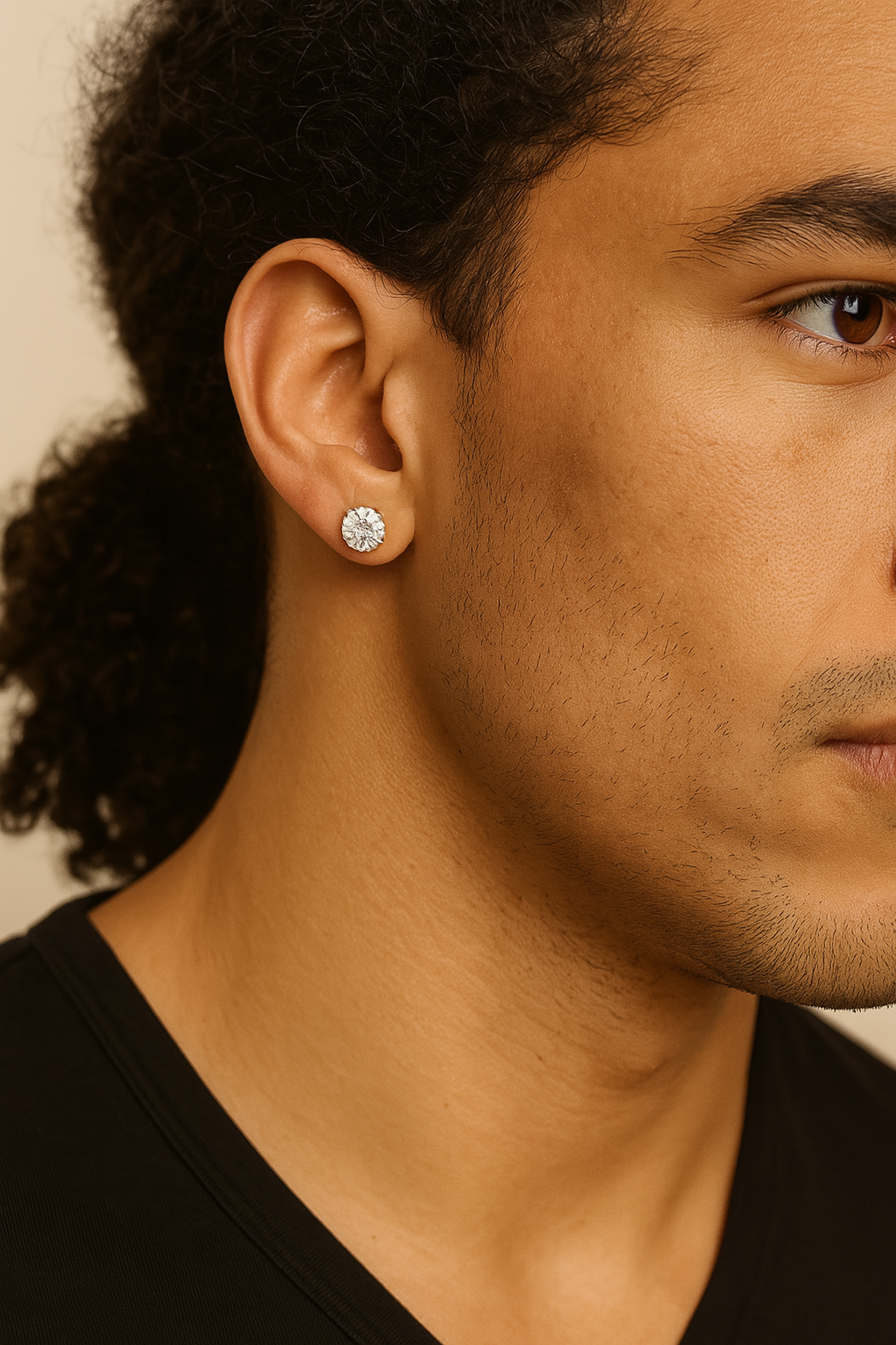 Close-up of a person wearing a diamond earring with a neutral background