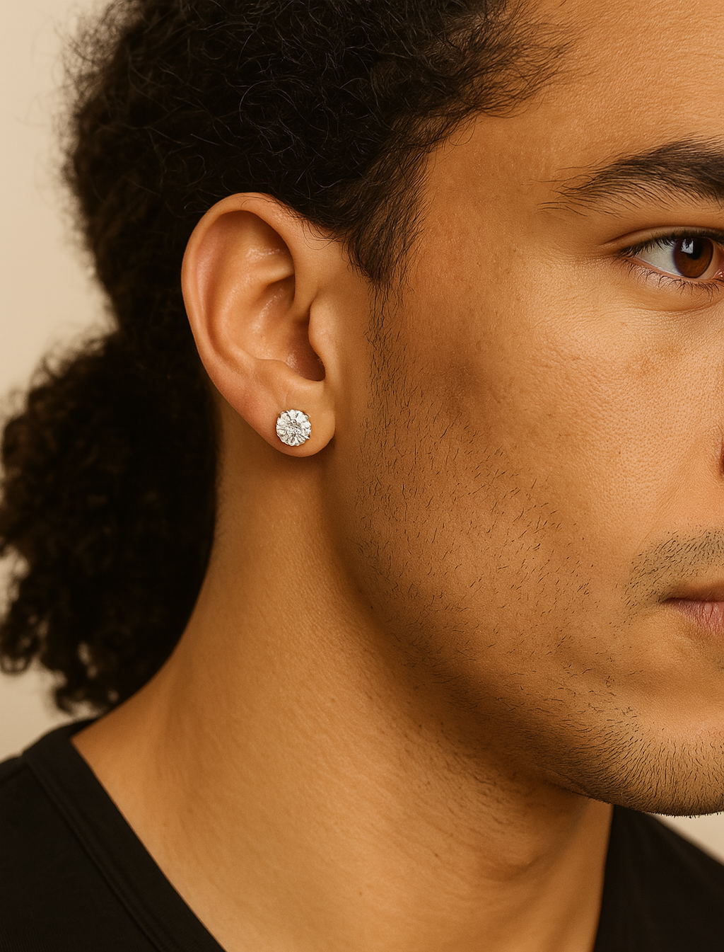 Close-up of a person wearing a diamond earring with a neutral background