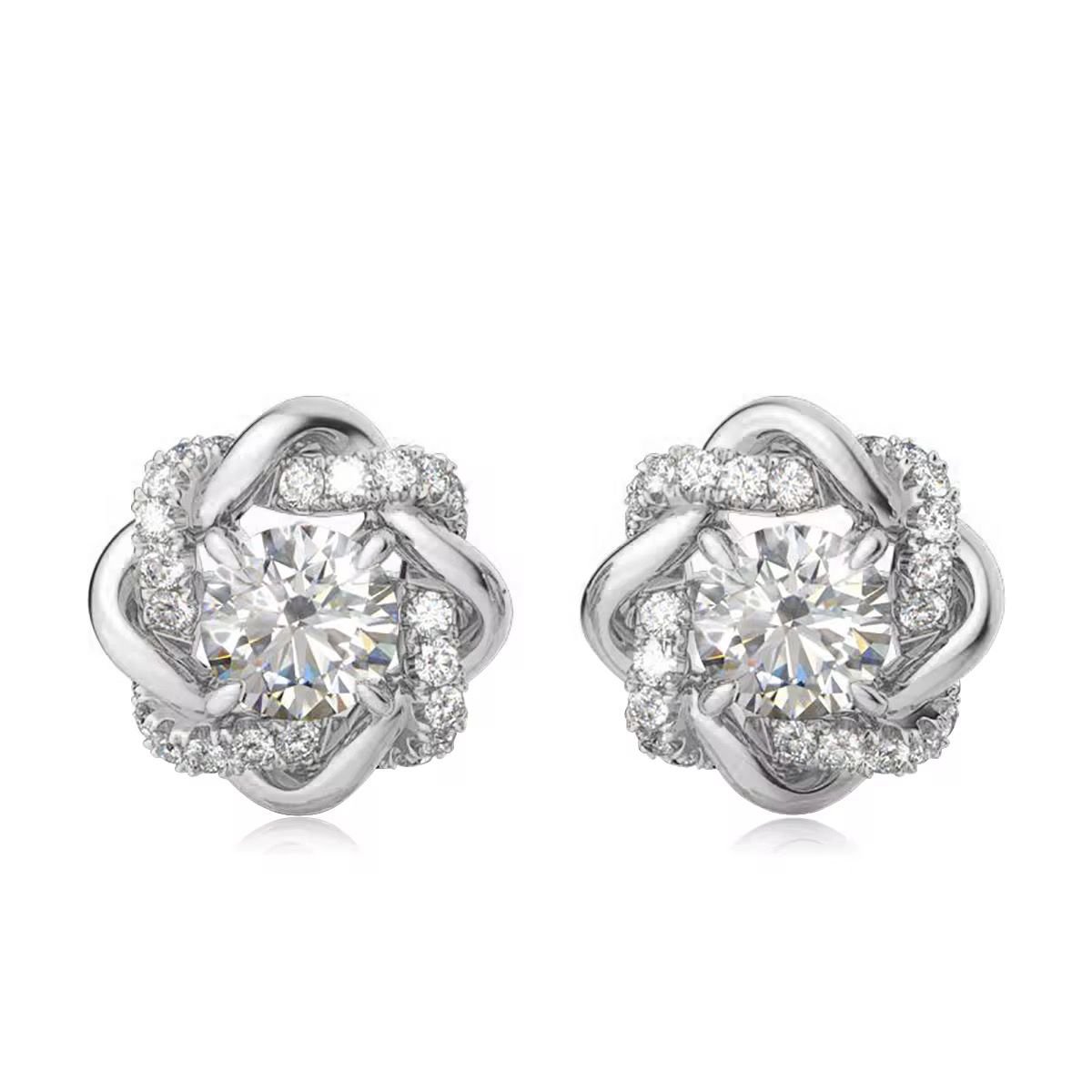 Pair of silver earrings with clear gemstones on a white background