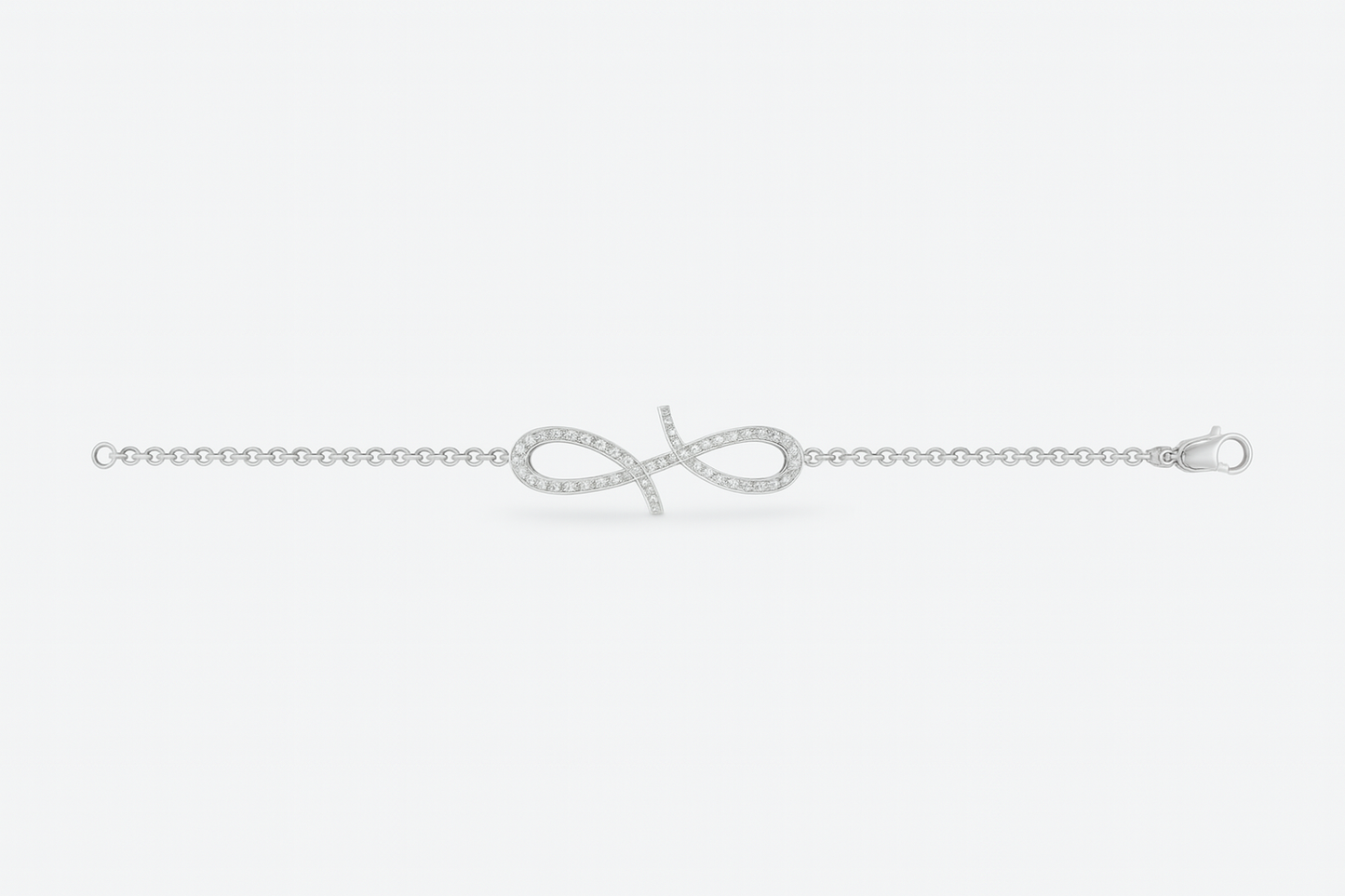 Silver bracelet with a bow design on a light gray background
