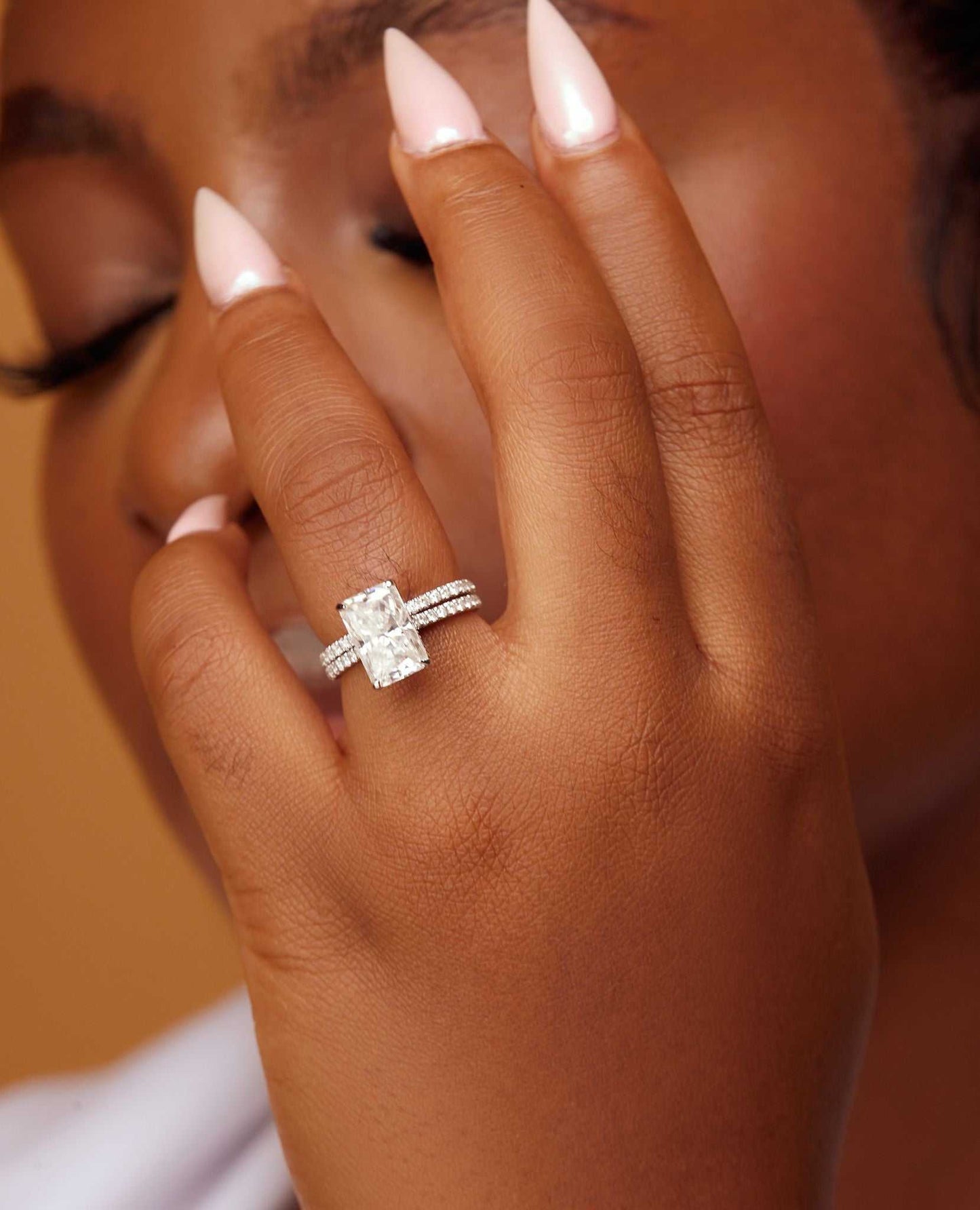 Simi Natural Diamond and Moissanite radiant-cut bridal ring set in 18K gold on a woman's hand