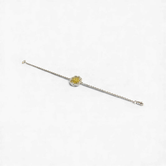 Silver bracelet with a yellow gemstone on a white background