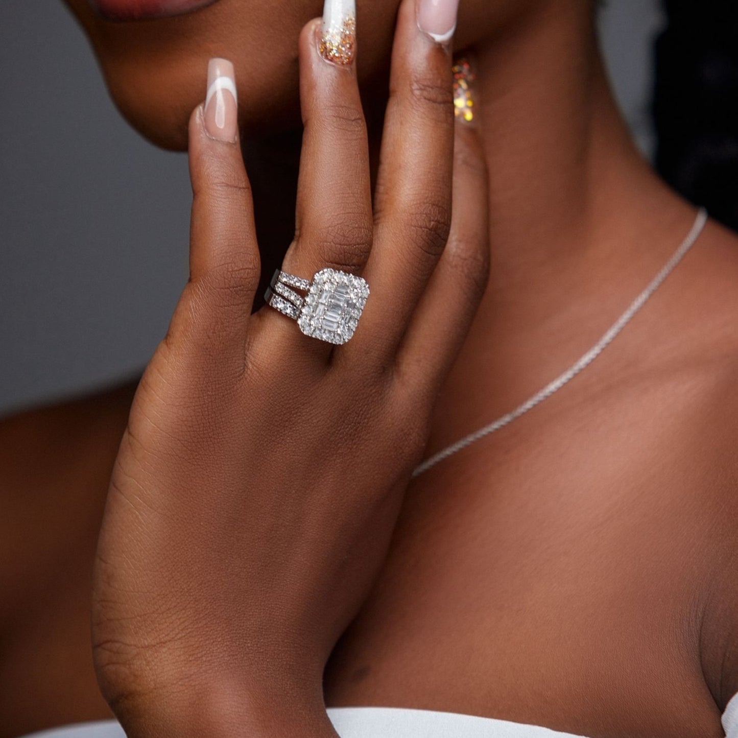 Close-up of a hand wearing a diamond ring with a blurred background