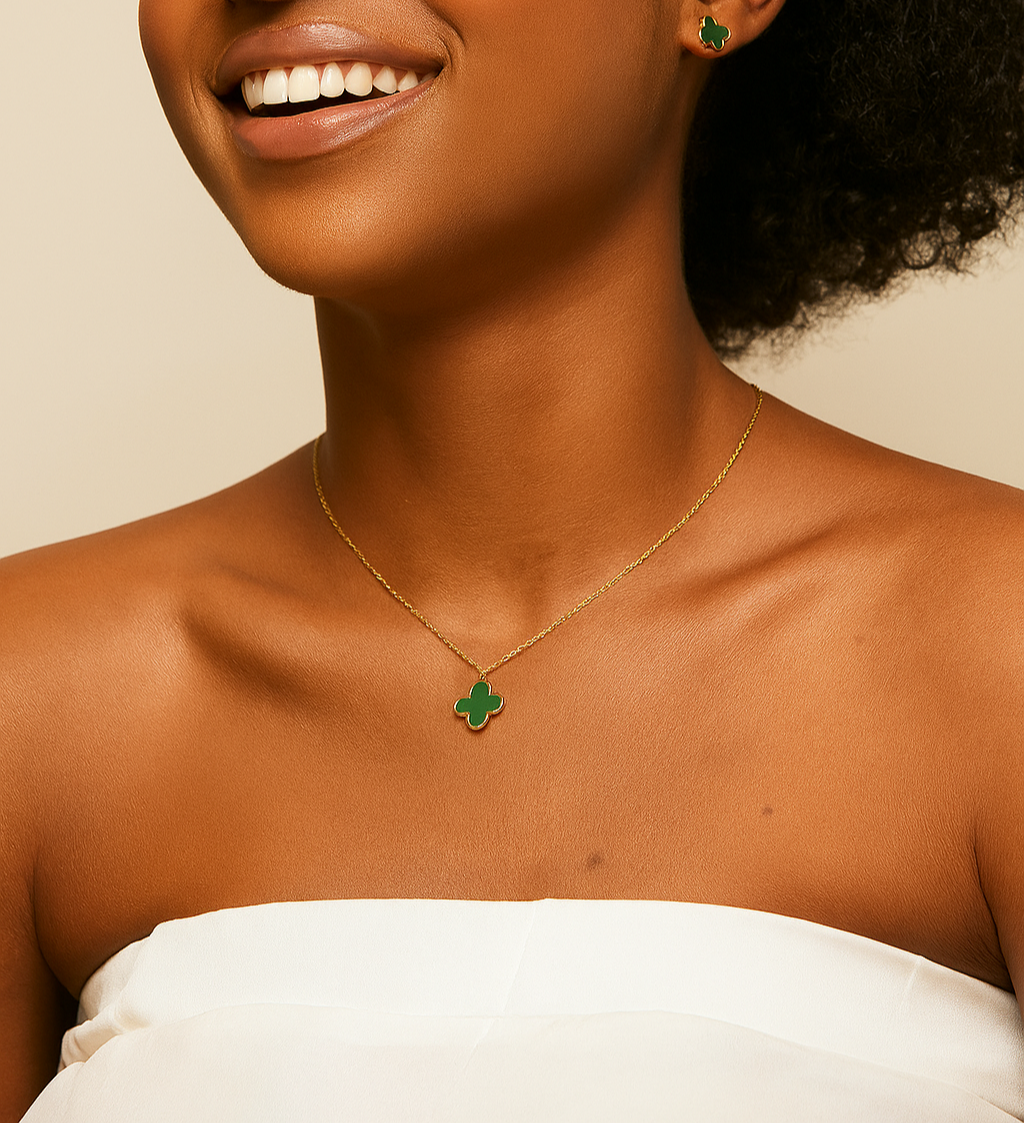 Woman wearing a gold necklace with a green pendant against a beige background