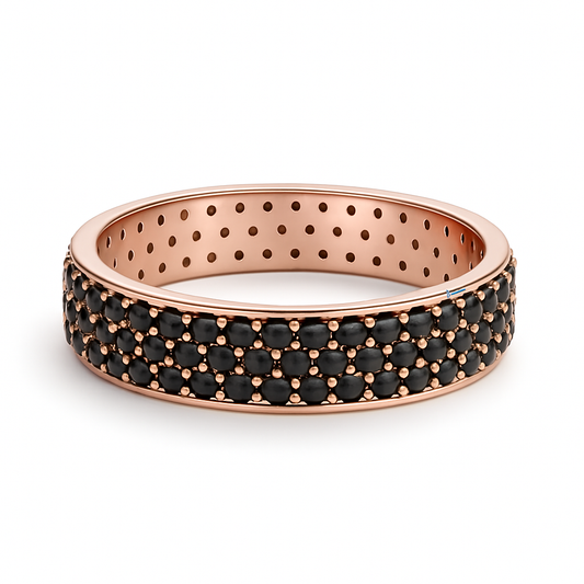 Rose gold ring with black gemstones on a white background