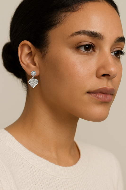 Close-up of a woman wearing heart-shaped earrings with a neutral background