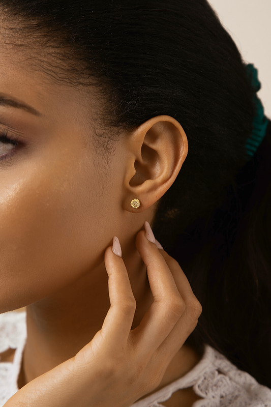 Close-up of a woman wearing a gold earring with a blurred background