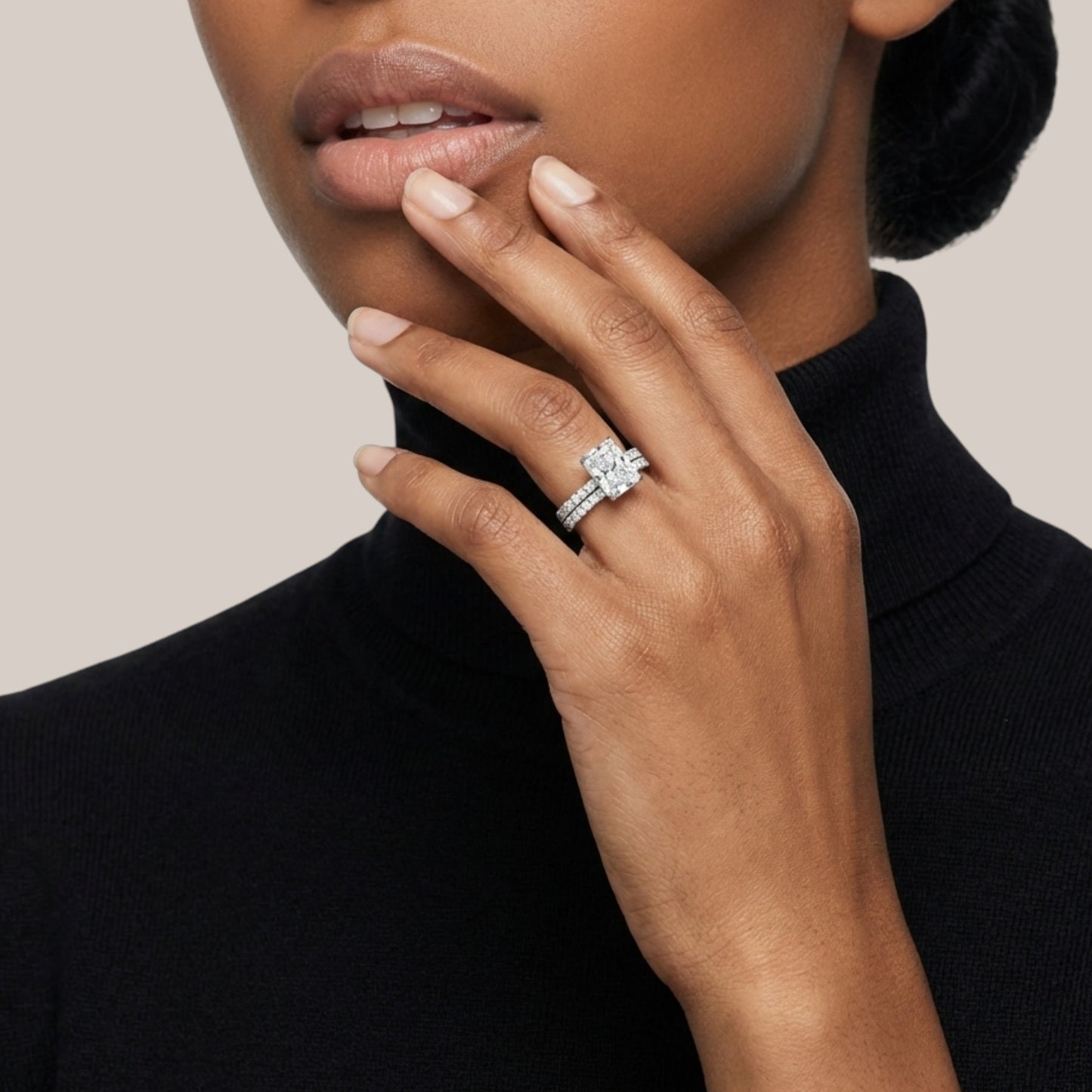 Close-up of a hand wearing a diamond ring with a neutral background