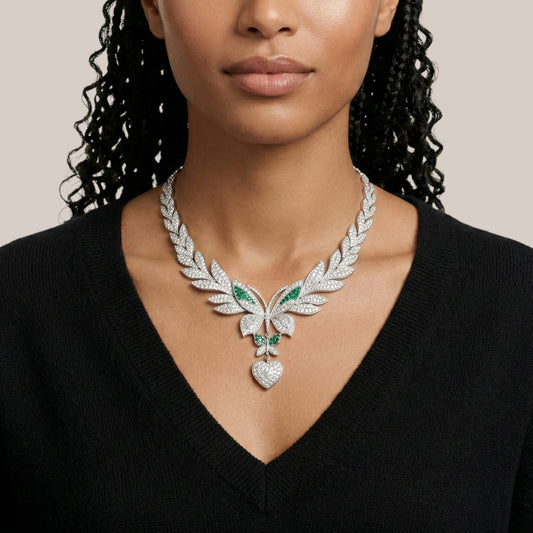 Woman wearing a luxurious diamond necklace with green gemstones on a neutral background