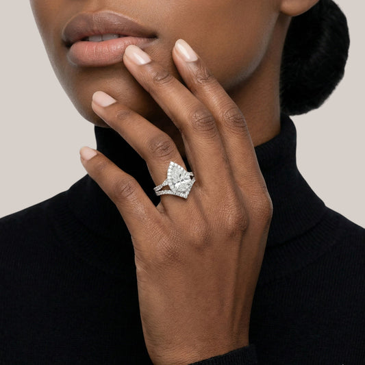 Close-up of a hand wearing a diamond ring with a neutral background