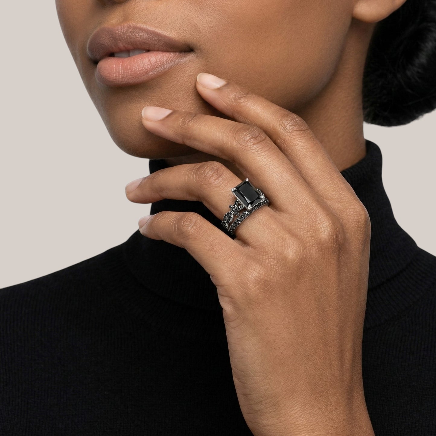 Close-up of a hand wearing a ring with a black background
