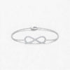 Silver infinity bracelet on a light gray background