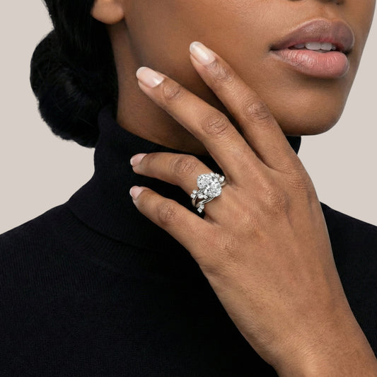 Close-up of a hand wearing a diamond ring with a neutral background