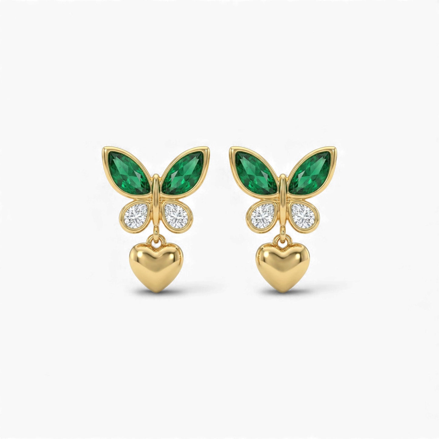 Gold butterfly earrings with green gemstones and heart pendants on a white background
