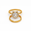 Gold ring with a large central gemstone and smaller stones on a white background
