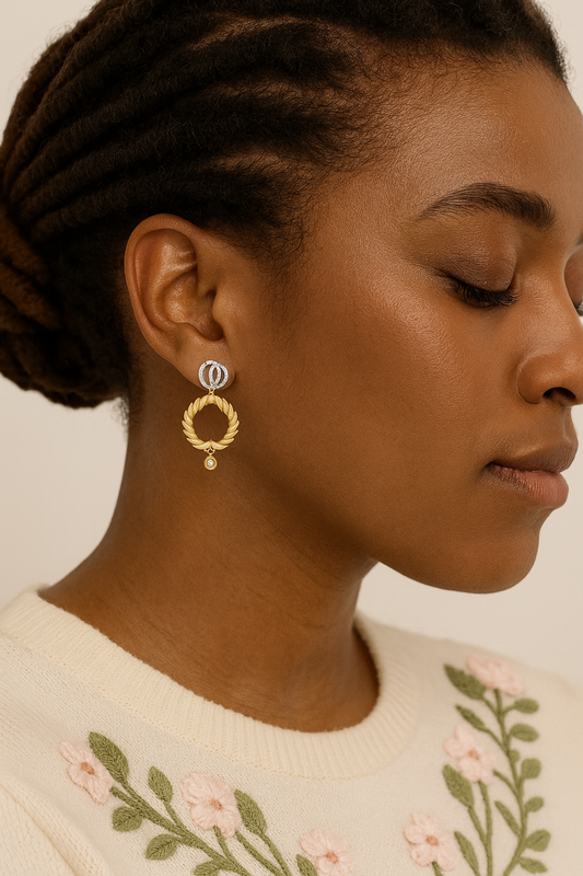 Woman wearing gold earrings with a neutral background
