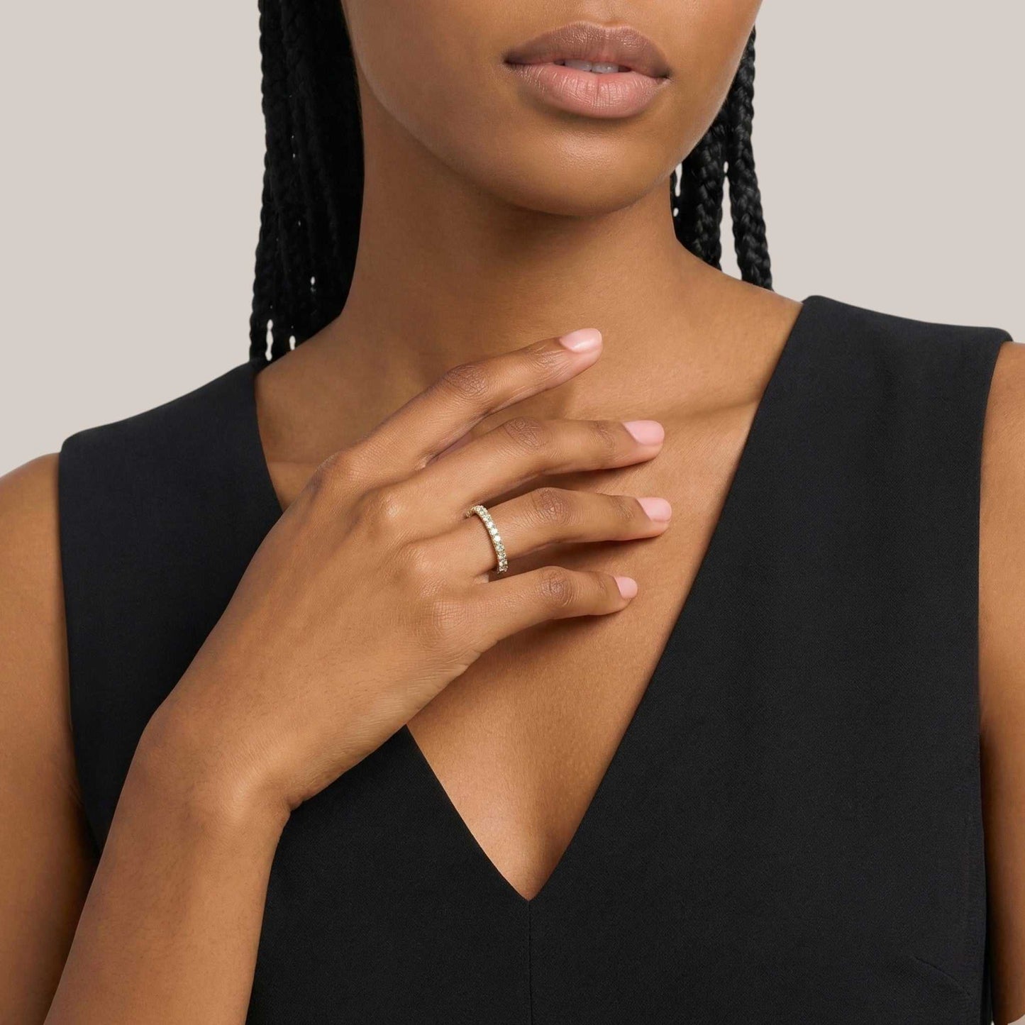 Woman wearing a black sleeveless top with a neutral background