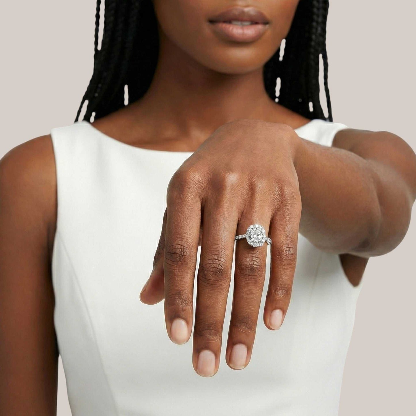 Woman wearing a diamond ring on her hand against a neutral background