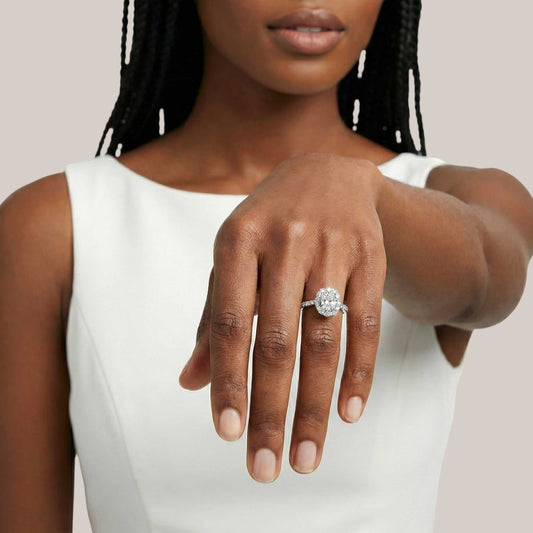 Woman wearing a diamond ring on her hand against a neutral background