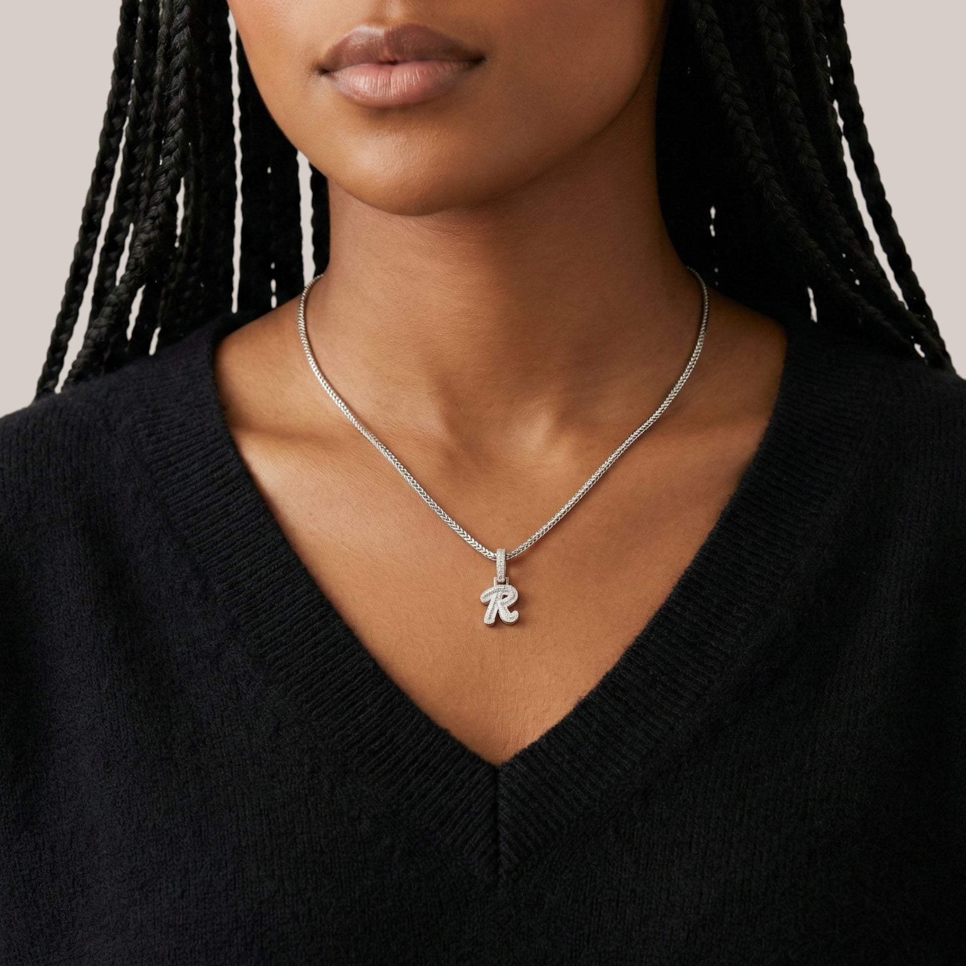 Person wearing a silver necklace with a pendant