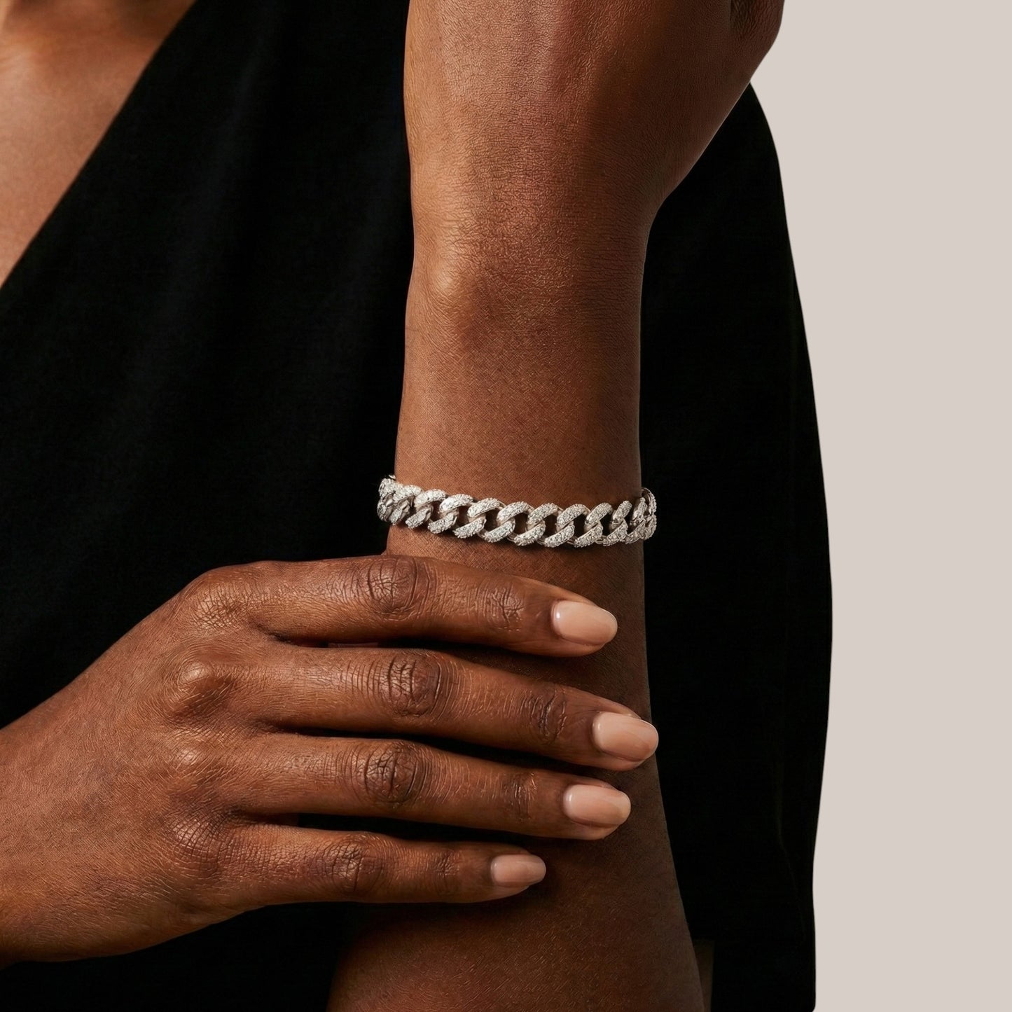 Person wearing a white braided bracelet on a neutral background