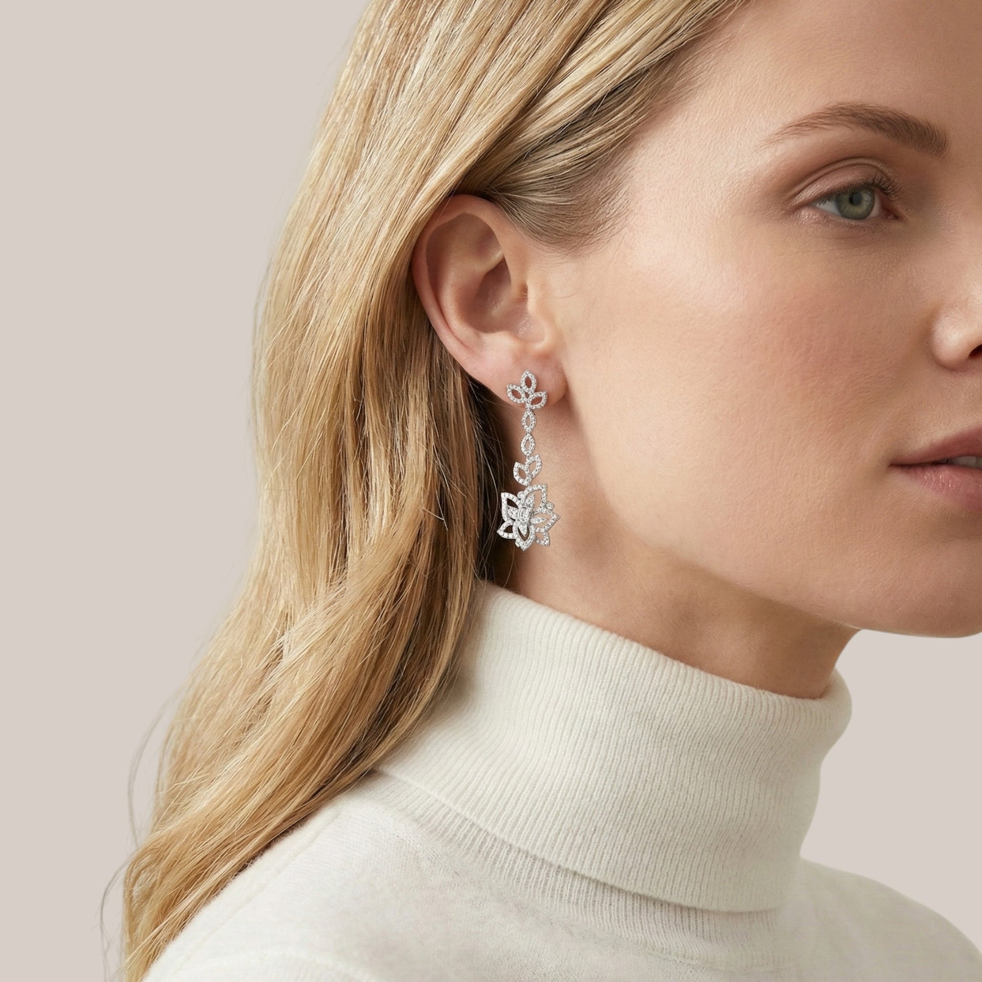 Close-up of a woman wearing silver earrings with a neutral background