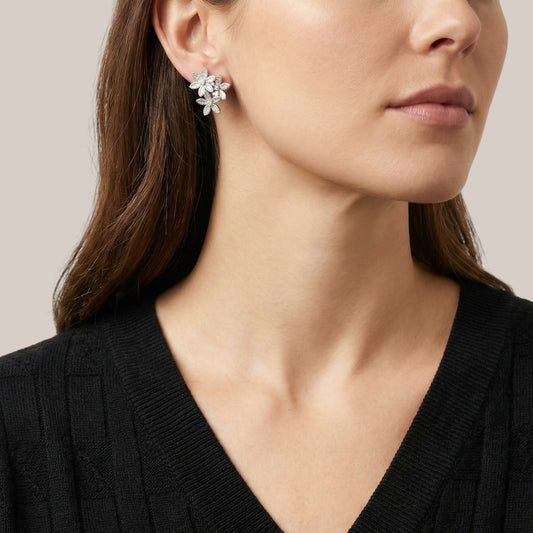 Close-up of a woman wearing a floral earring with a neutral background
