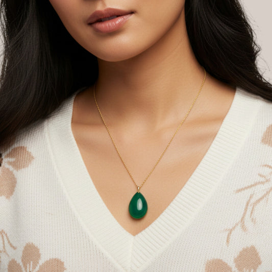 Woman wearing a gold necklace with a green pendant